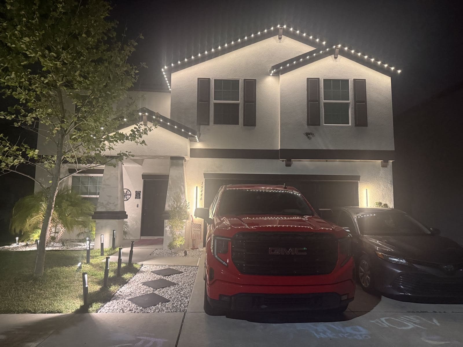 Two-story home at night with permanent accent lighting along the roofline