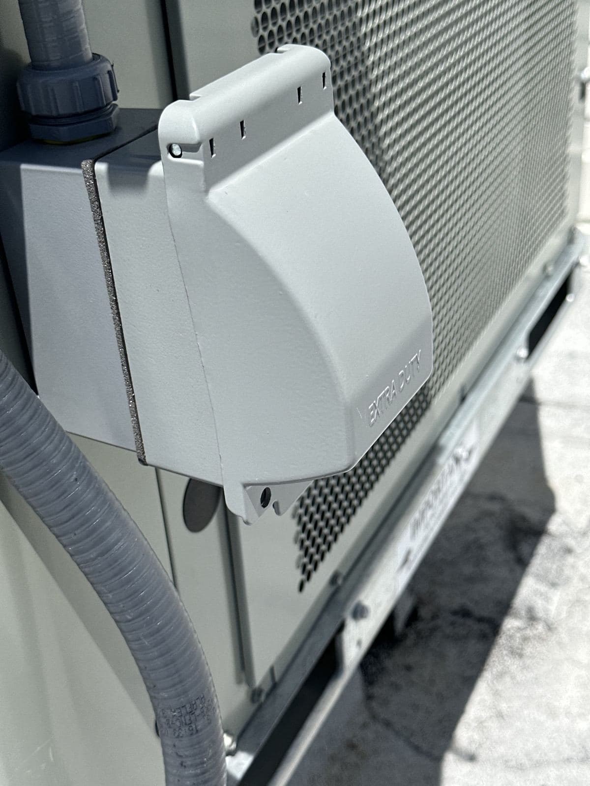 Weatherproof power inlet and flexible conduit installed on outdoor equipment